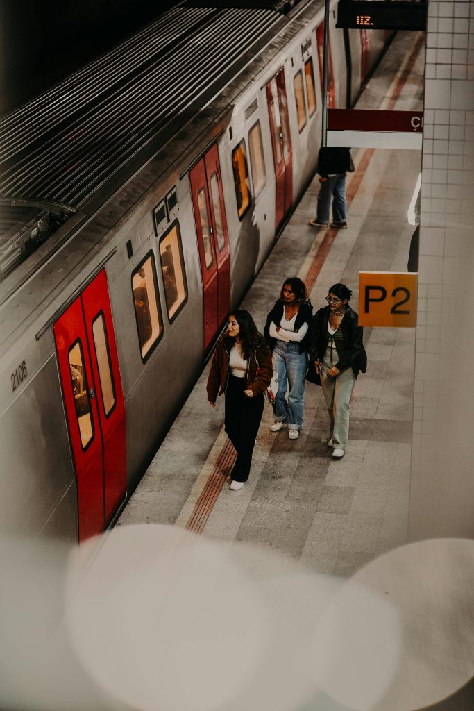 Three people walking along a subway platform in Ankara, Türkiye.